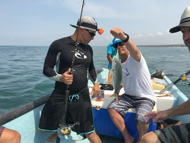 Alex and MD with a fish on during a Mexico surf trip